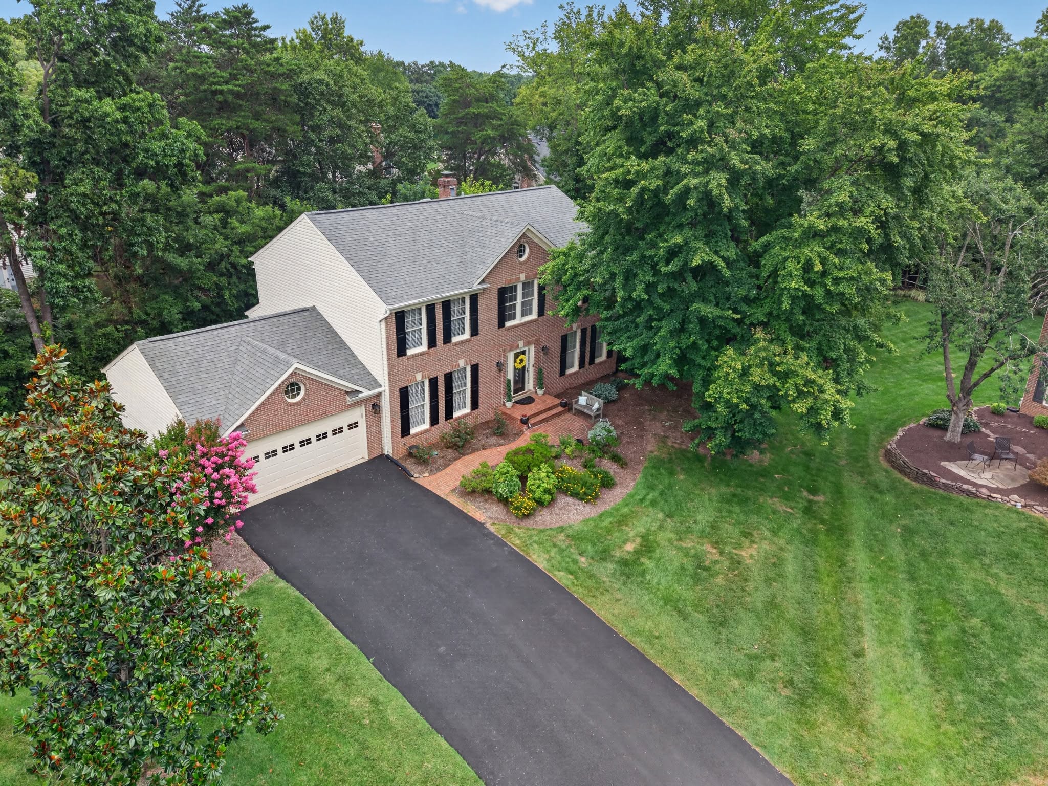 Aerial view of a brick colonial home and its driveway