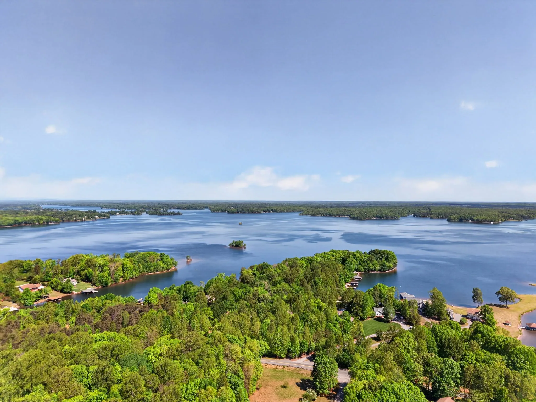 High aerial view across an expansive lake with wooded points and coves