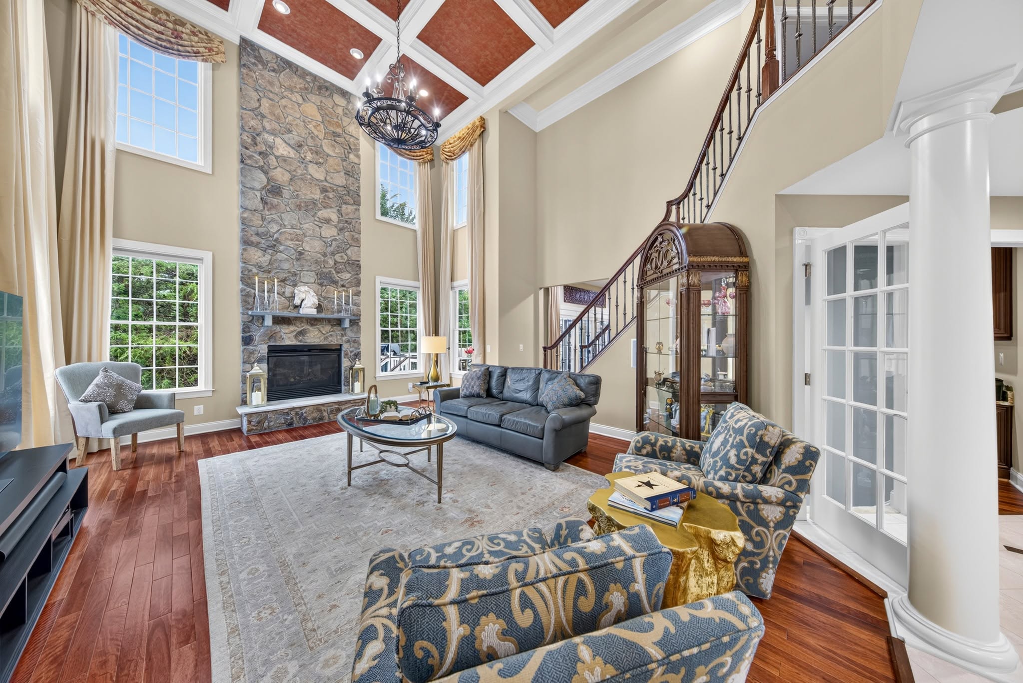 Living room with a stone fireplace and a coffered ceiling