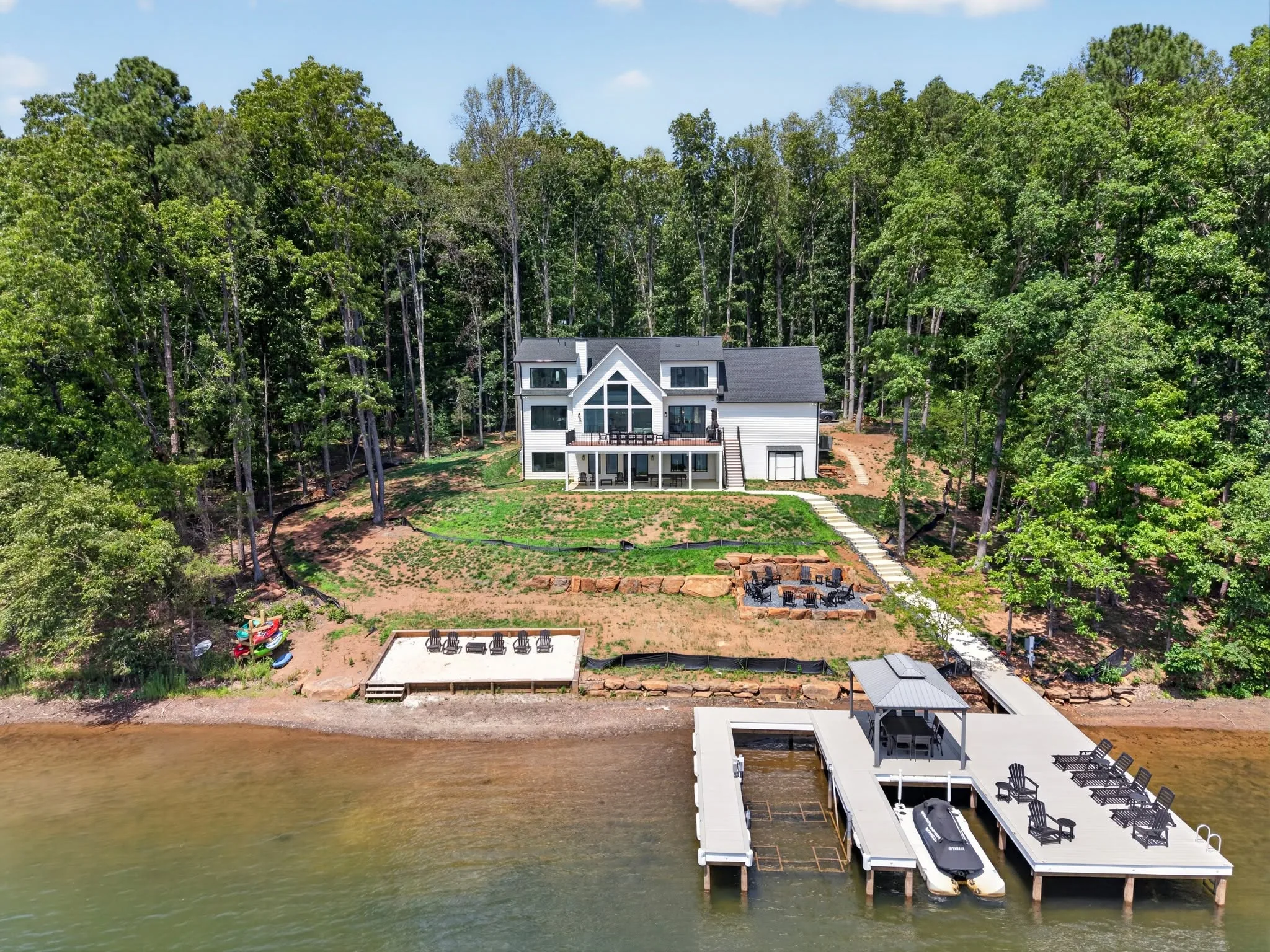 Aerial photograph of a lakefront home with a covered dock and boat lift on the water