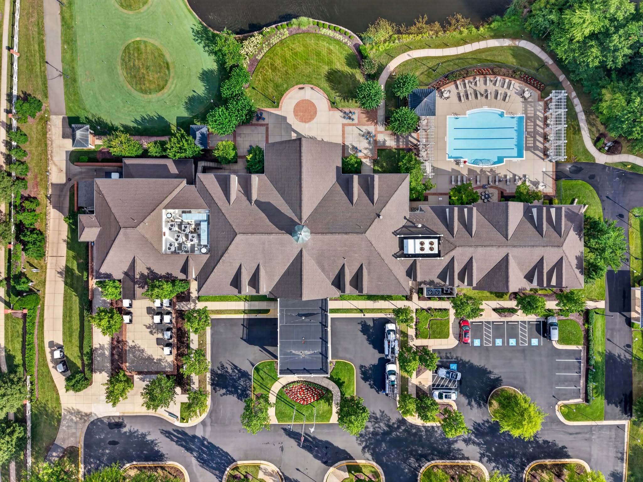 Overhead aerial view of a clubhouse, pool and golf course