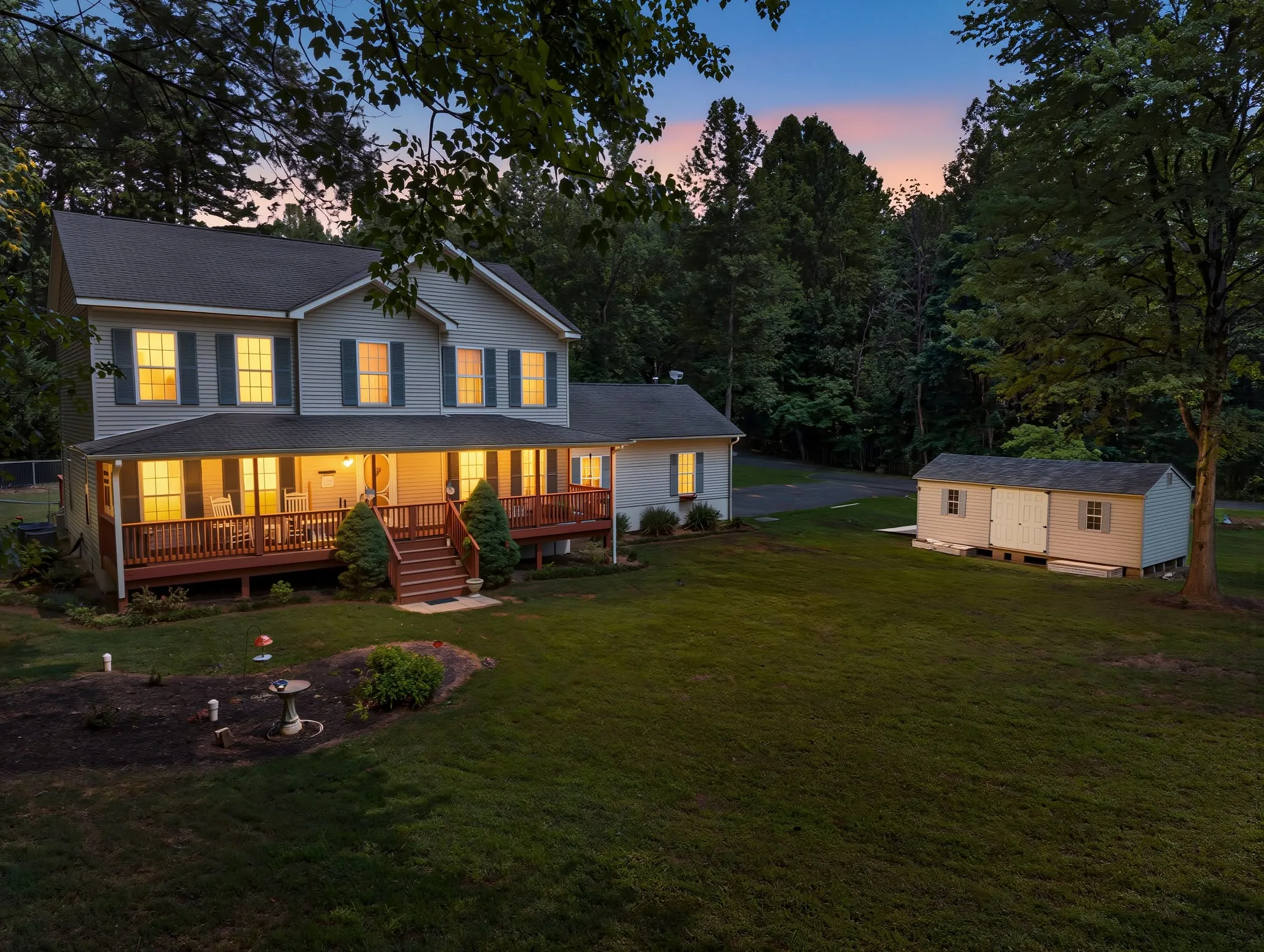 Colonial home with a covered front porch photographed in the blue hour