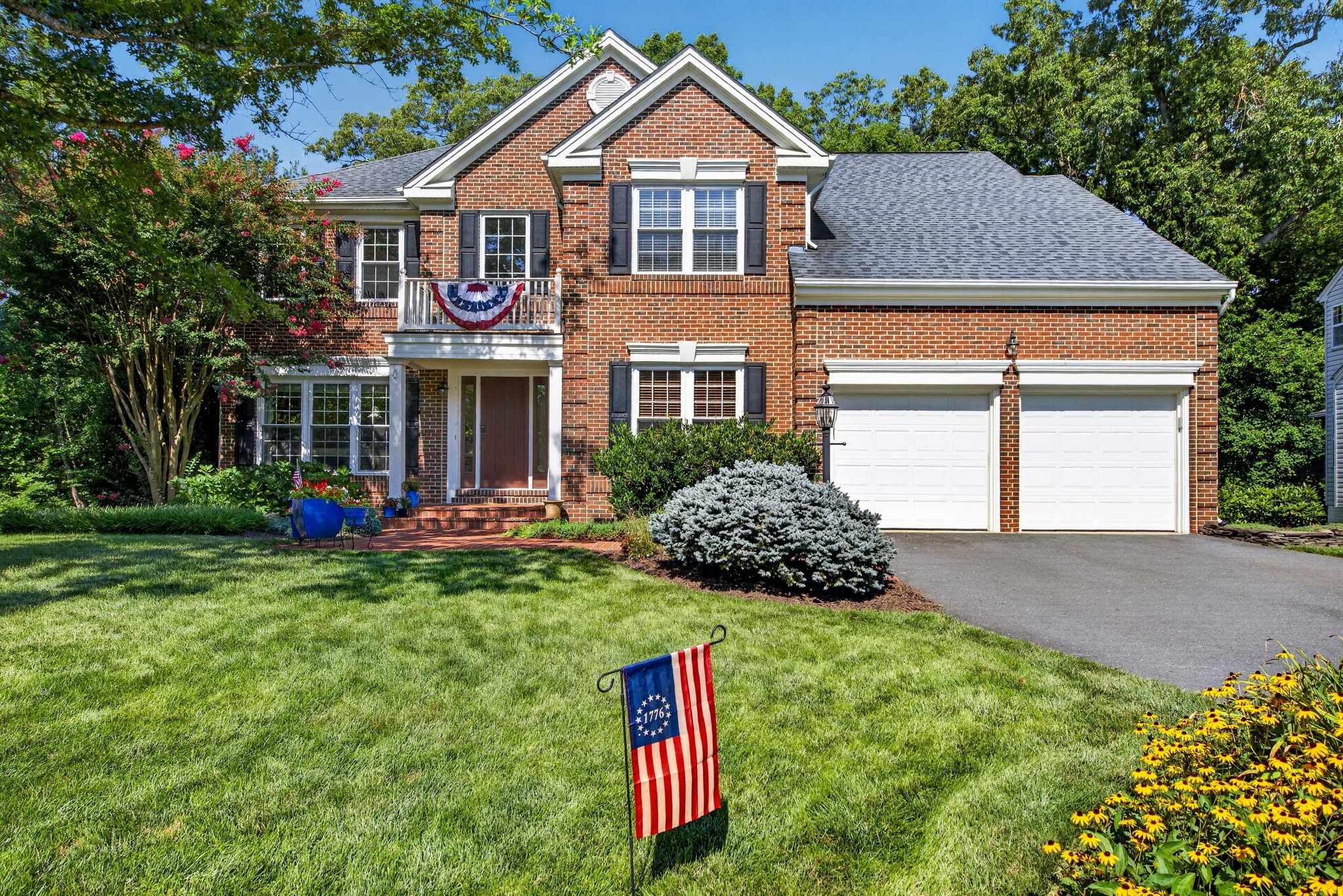 Brick colonial home viewed across a green front lawn