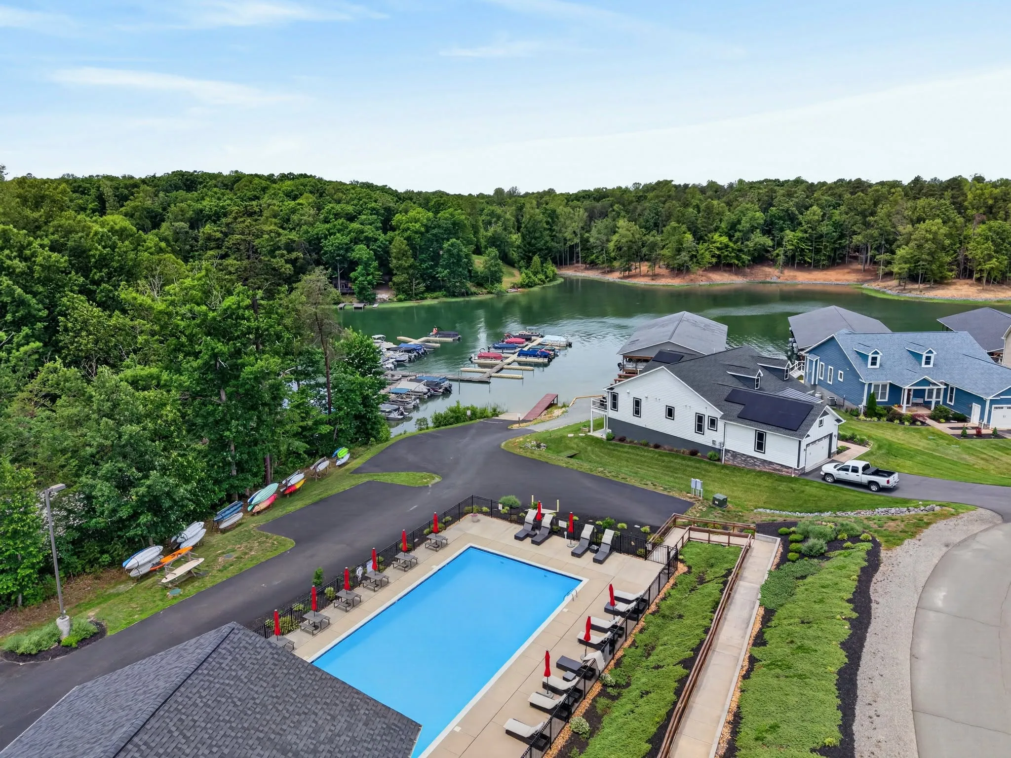 Aerial view of a neighborhood community pool surrounded by homes and mature trees