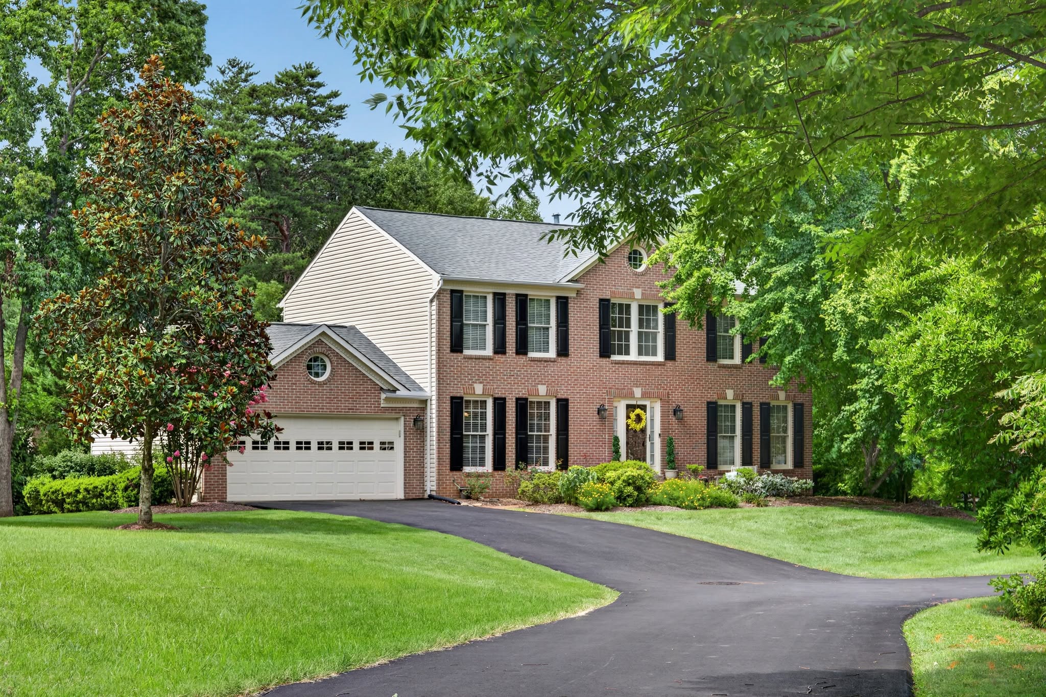 Brick colonial home at the end of a long driveway