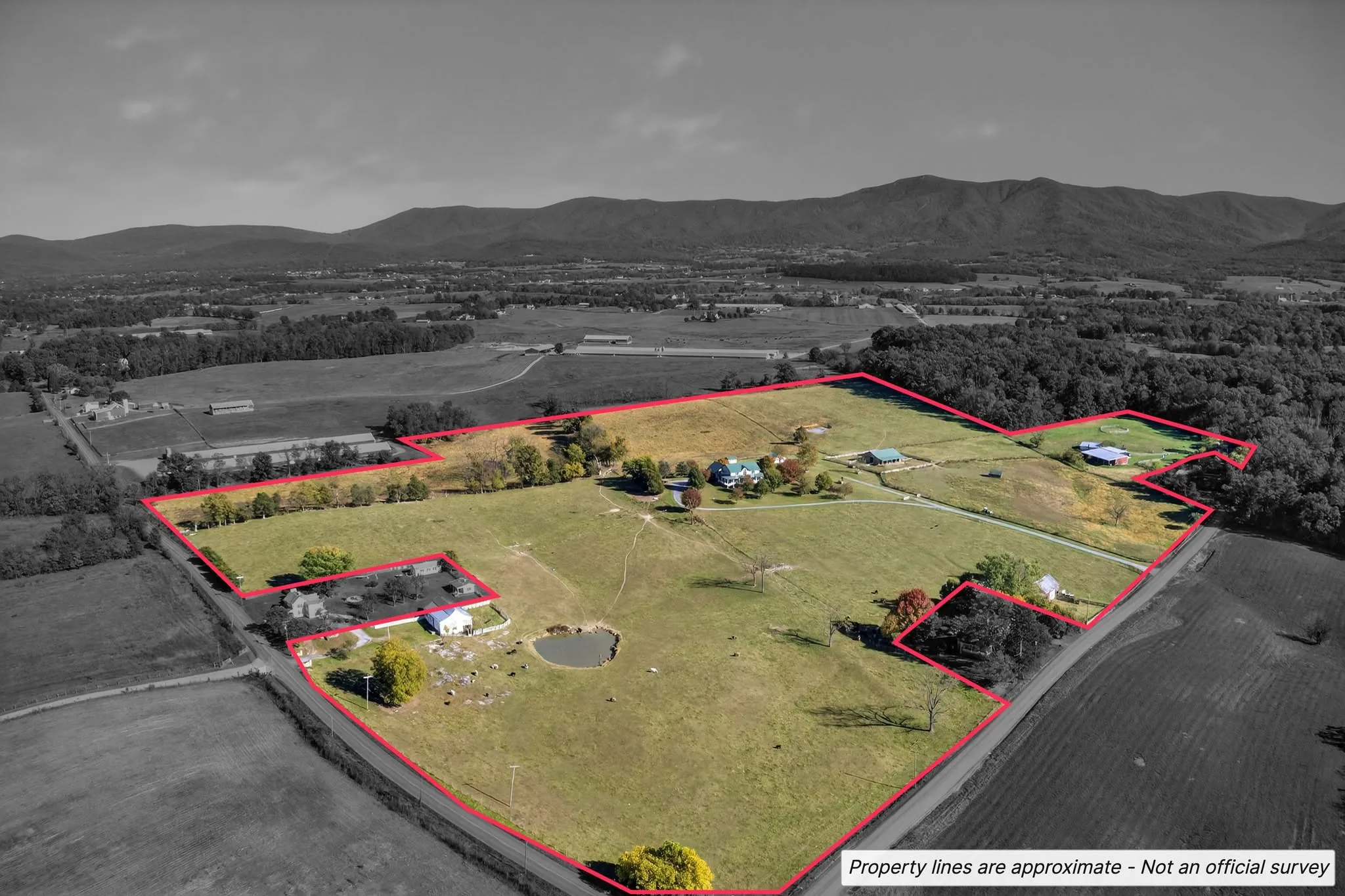Aerial photograph of acreage below a mountain ridge with approximate property lines drawn in red